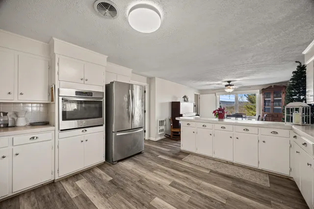 a spacious bathroom with a granite countertop sink a toilet and a mirror
