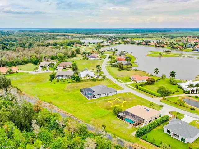 an aerial view of residential houses with outdoor space and ocean view