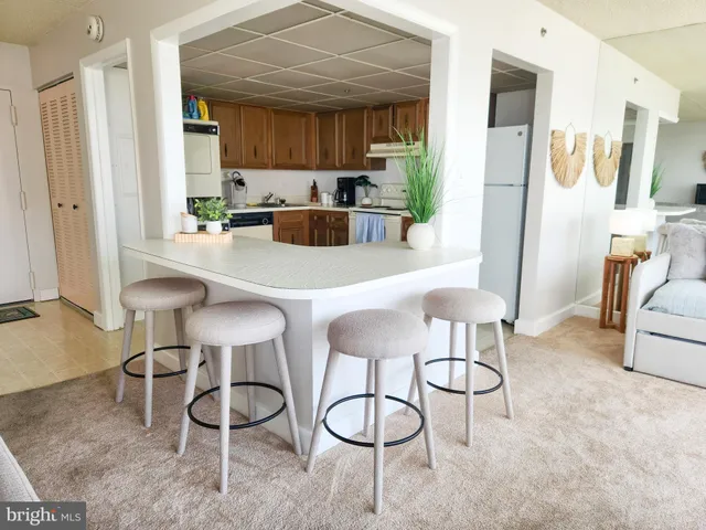 a kitchen with stainless steel appliances a table and chairs in it