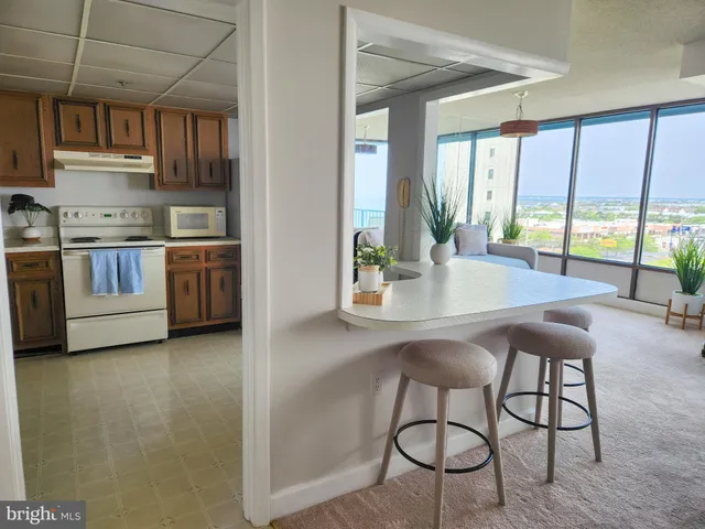 a kitchen with stainless steel appliances a table and chairs in it