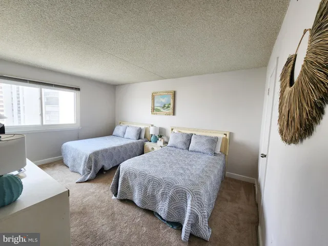 a bedroom with two beds and painting on the wall