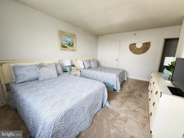 a bedroom with two beds and a flat screen tv