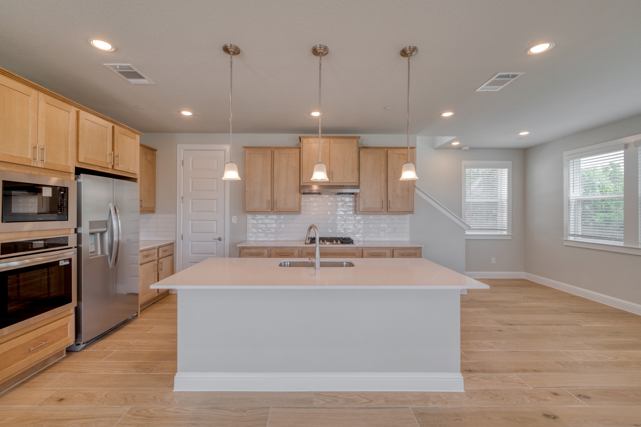 2605 Sam Bass Road, Unit 44 Round Rock, TX 78681 - Photo 9 of 26 An inviting kitchen with a central island and contemporary light fixtures, seamlessly connecting to an open living and dining area.