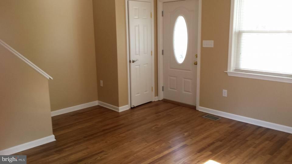 1680 Poles Road Essex, MD 21221 - Photo 5 of 15 an empty room with wooden floor and mirror