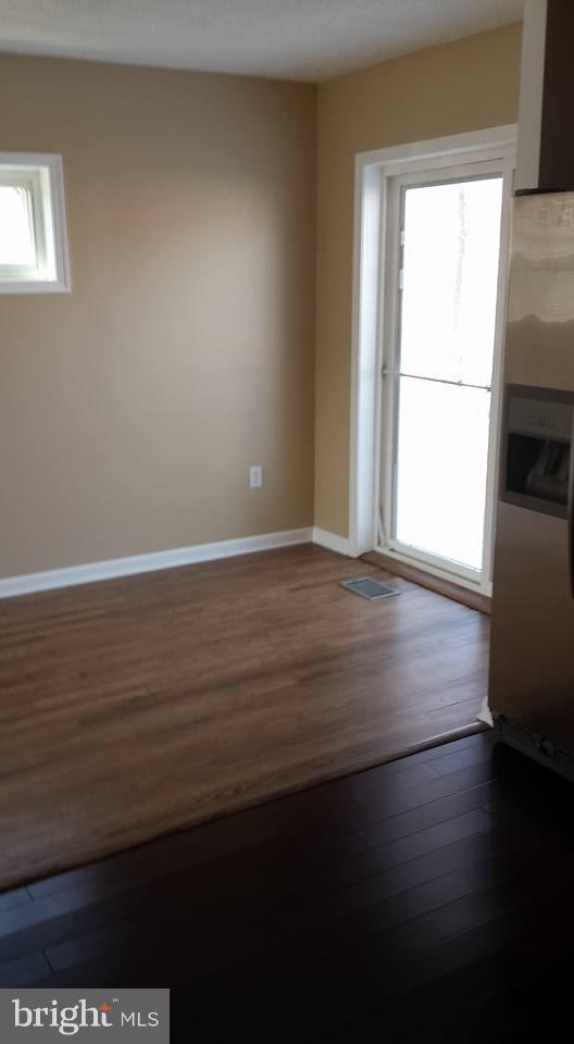 1680 Poles Road Essex, MD 21221 - Photo 8 of 15 a view of an empty room with wooden floor and a window