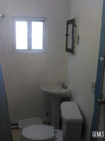 a bathroom with a toilet a sink and mirror