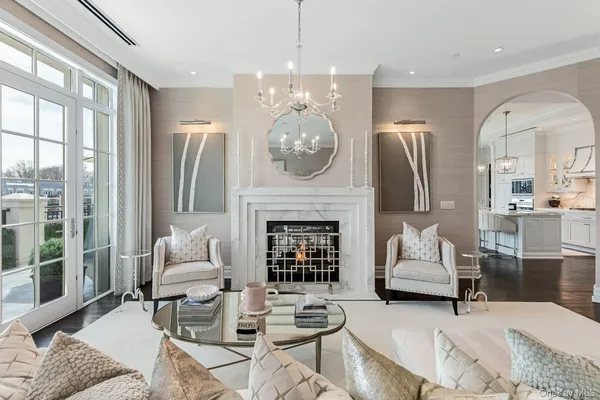 a living room with furniture chandelier and a fireplace