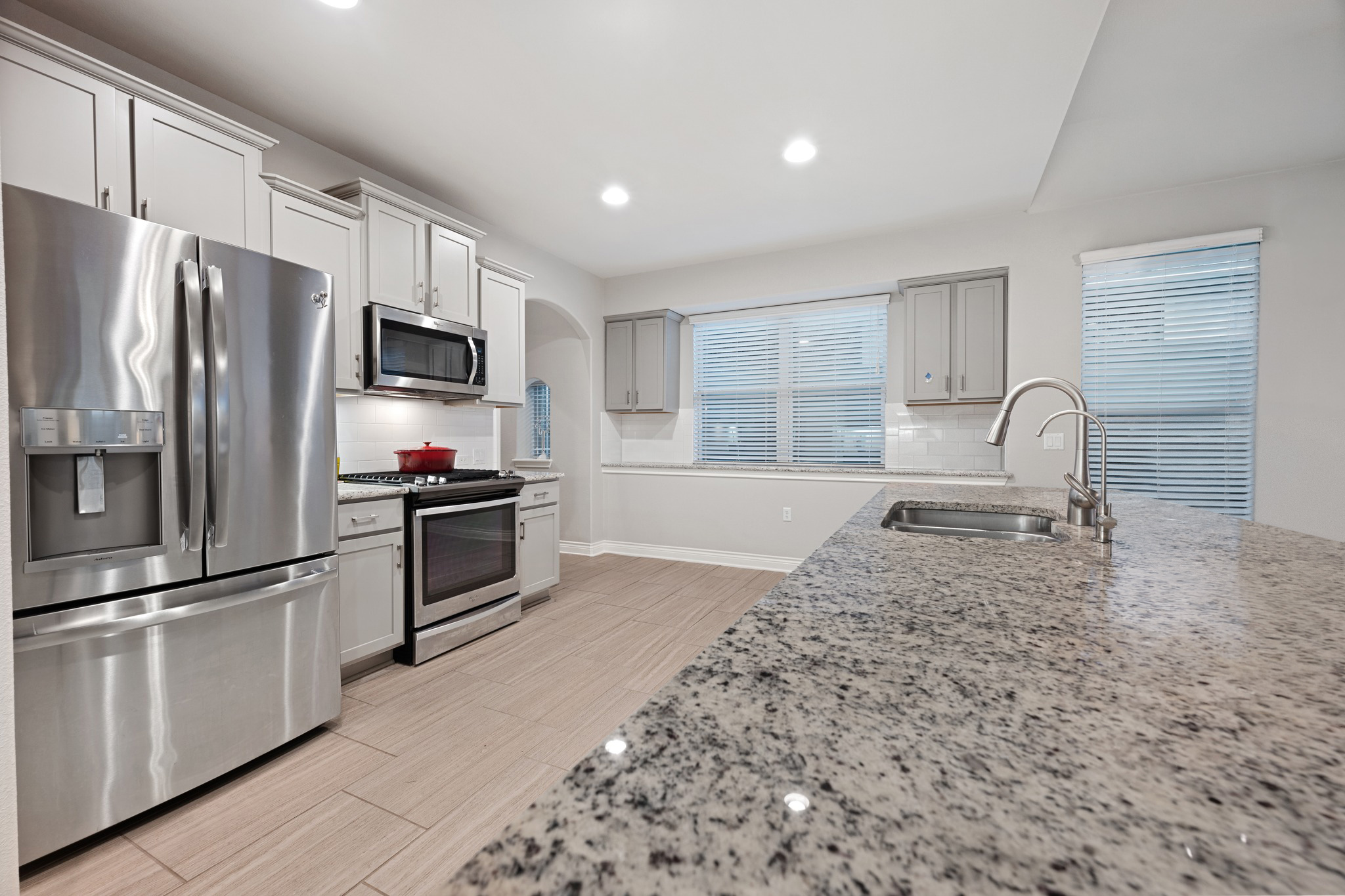 6405 Alleyton Drive Austin, TX 78721 - Photo 5 of 30 a kitchen with granite countertop a refrigerator stove and sink