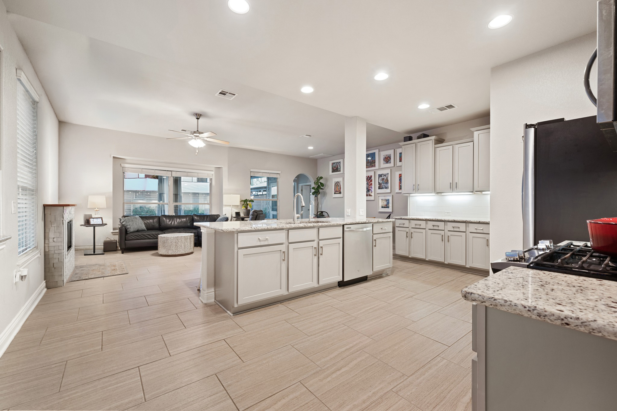 6405 Alleyton Drive Austin, TX 78721 - Photo 7 of 30 a large white kitchen with a refrigerator a stove a sink a dining table and chairs