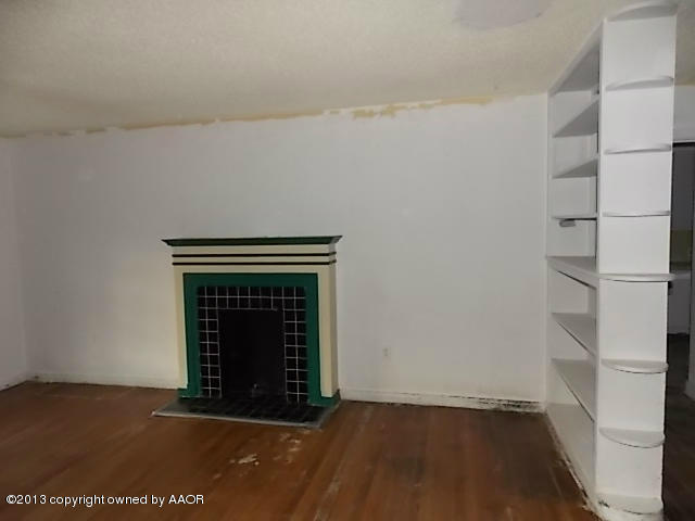 4101 South Travis Street Amarillo, TX 79110 - Photo 10 of 14 a view of an empty room with a fireplace and a window