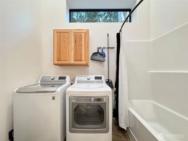 a backyard of a house with large trees and wooden fence