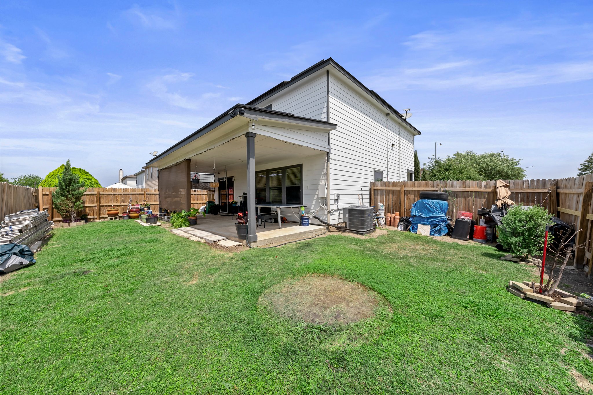 6829 Walkup Lane Austin, TX 78747 - Photo 17 of 18 A spacious grassy yard extends to a covered patio, perfect for outdoor leisure.