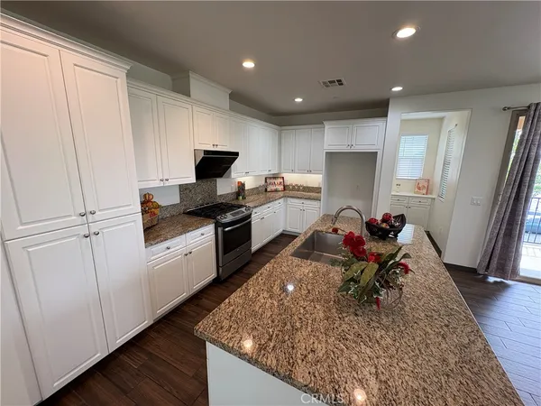 a kitchen with stainless steel appliances granite countertop a stove top oven a sink dishwasher and a refrigerator