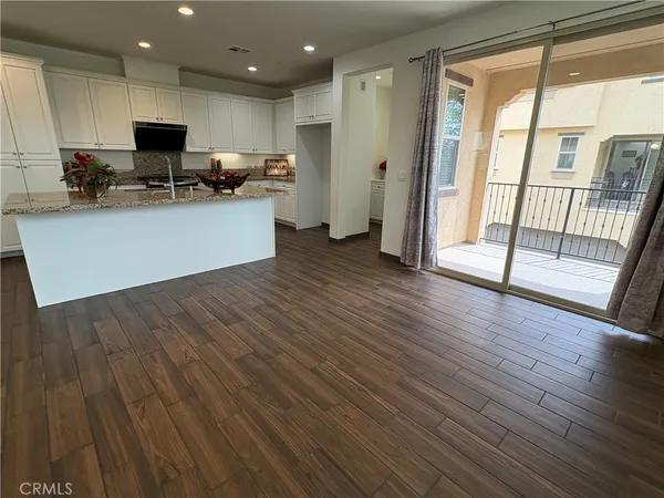 a kitchen with stainless steel appliances granite countertop a stove top oven a refrigerator and a large window