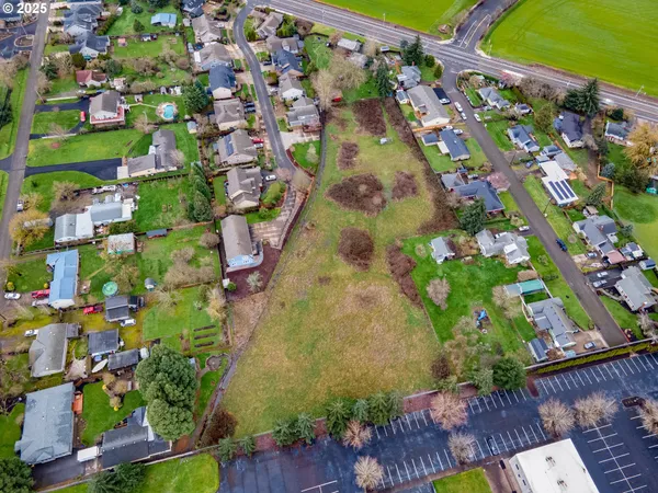 an aerial view of a house with a garden and lake view