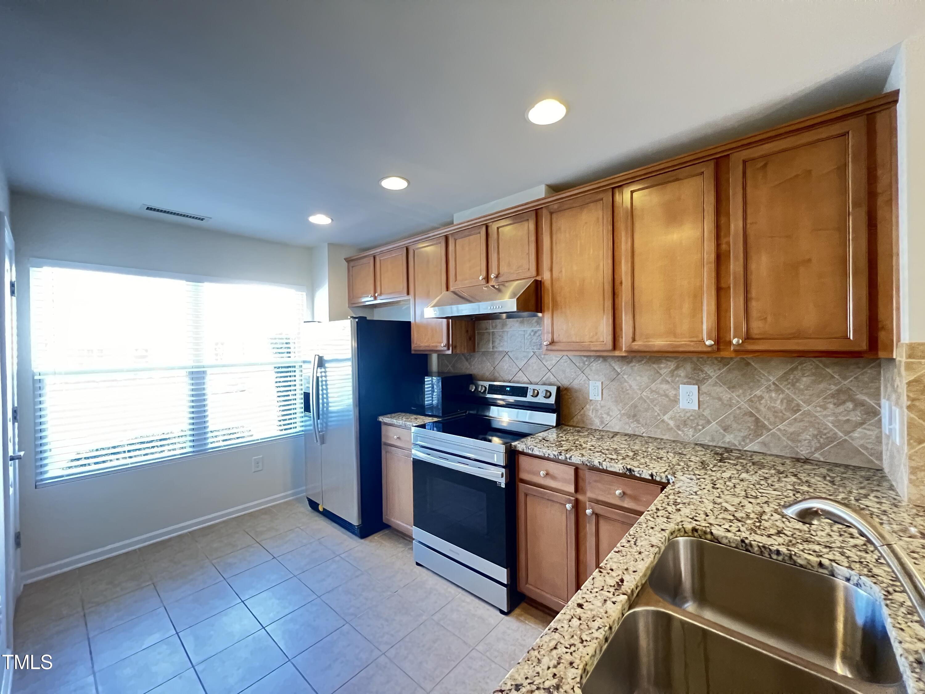 2919 Berkeley Springs Place Raleigh, NC 27616 - Photo 2 of 12 a kitchen with stainless steel appliances granite countertop a stove a sink and a refrigerator