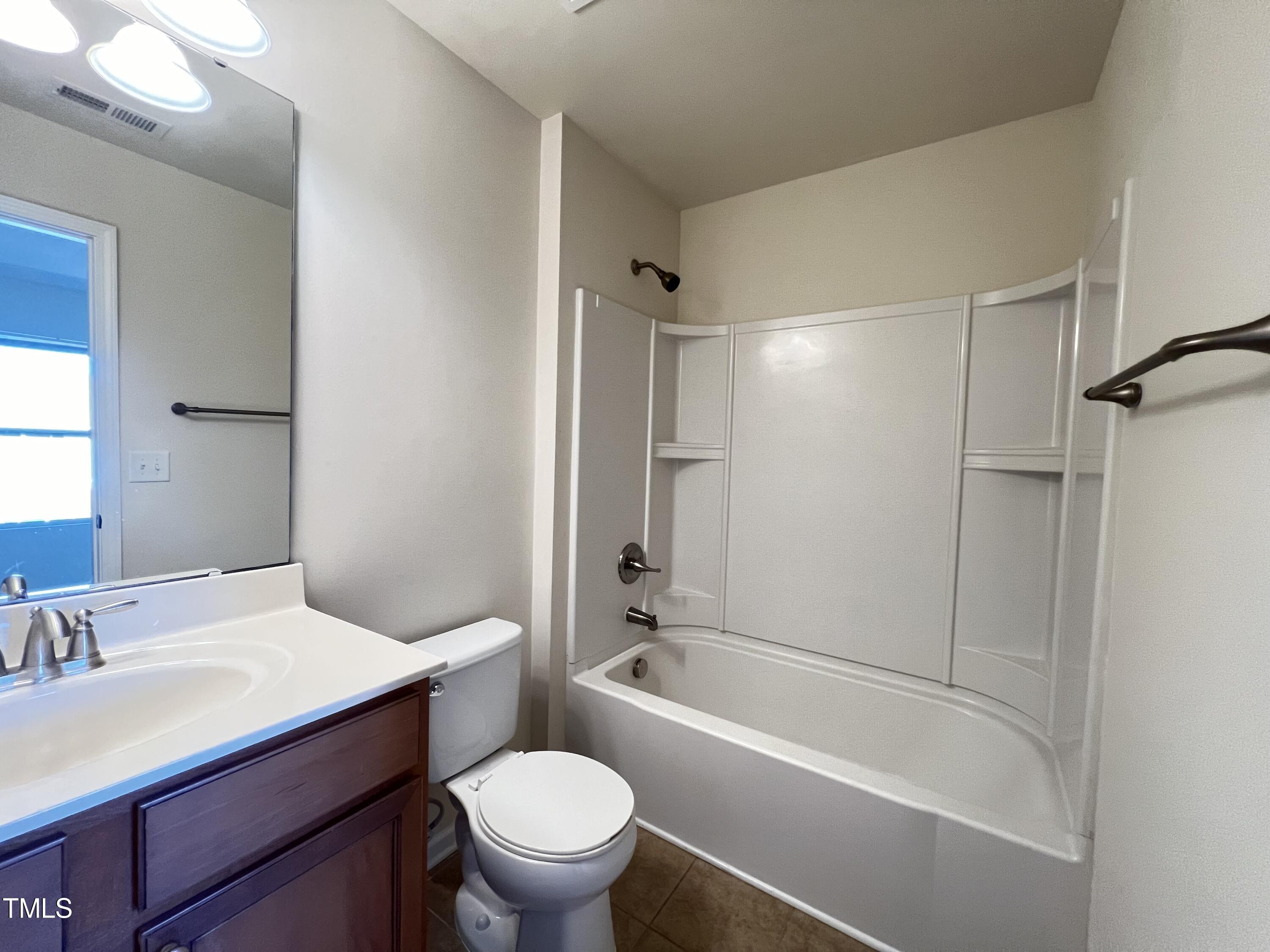 2919 Berkeley Springs Place Raleigh, NC 27616 - Photo 10 of 12 a bathroom with a bathtub shower sink vanity mirror and toilet