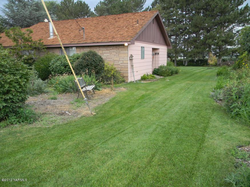 991 Olmstead Road Grandview, WA 98930 - Photo 13 of 17 a view of a house with backyard and a tree