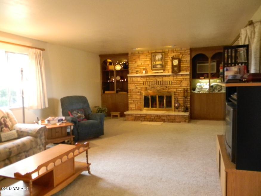 991 Olmstead Road Grandview, WA 98930 - Photo 6 of 17 a living room with furniture a fireplace and a large window