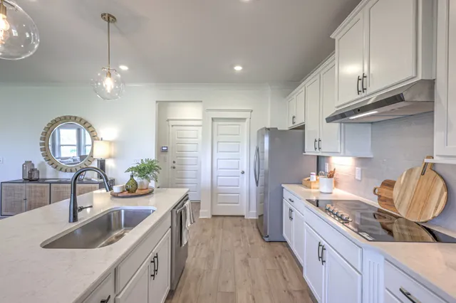 a kitchen with kitchen island granite countertop a sink stainless steel appliances and cabinets