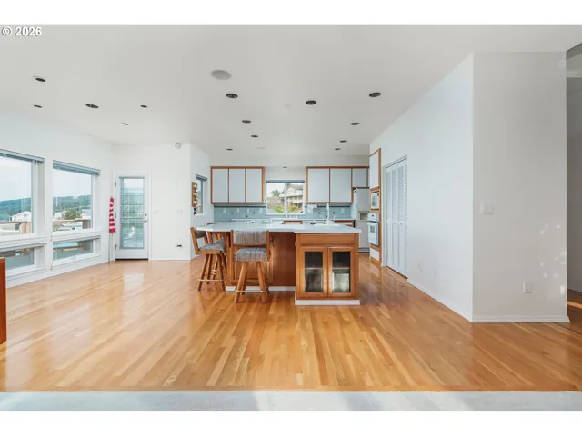 a kitchen with stainless steel appliances a dining table chairs and granite counter tops