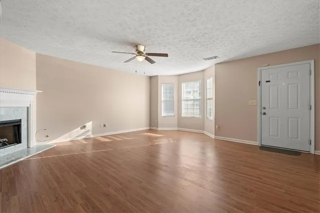 a view of empty room with wooden floor and fireplace