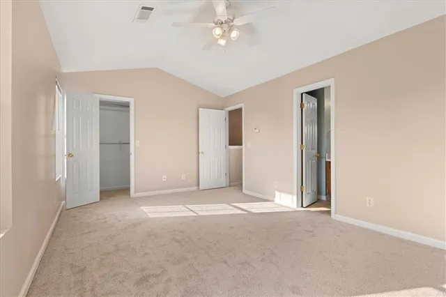 an empty room with closet and a ceiling fan