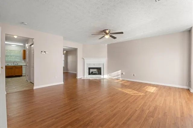 a view of empty room with wooden floor and fireplace