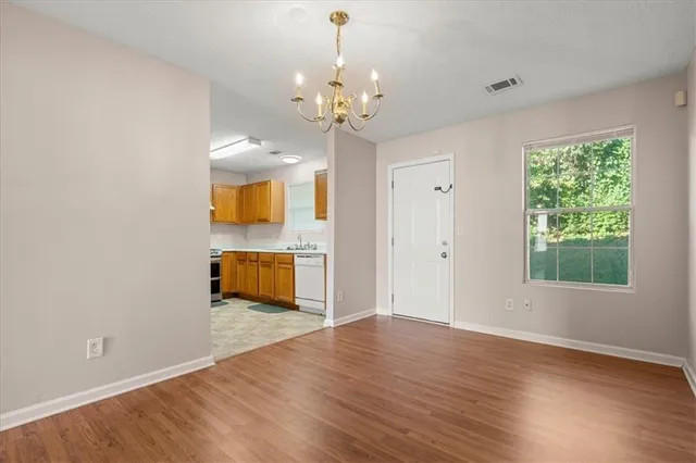 a view of a hallway with wooden floor and a chandelier