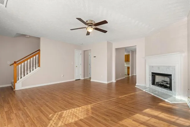 a view of empty room with wooden floor and fireplace