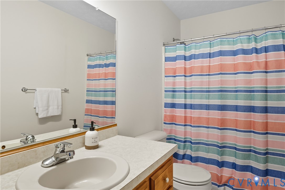 22419 Shippings Road McKenney, VA 23872 - Photo 20 of 35 a bathroom with a sink a toilet and shower curtain