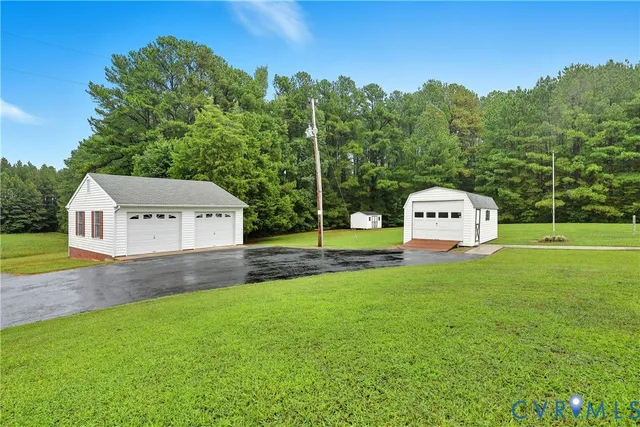 a view of a house with a yard and trees in the background