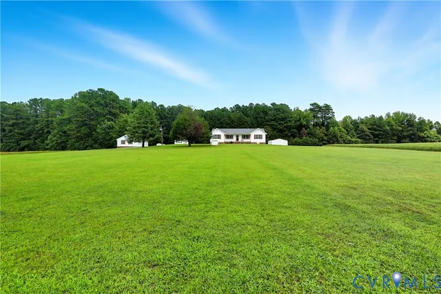a view of a grassy field with trees in the background