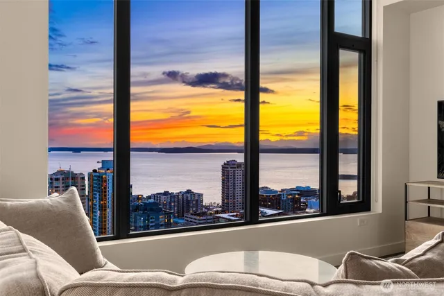 a living room with furniture city view and large windows