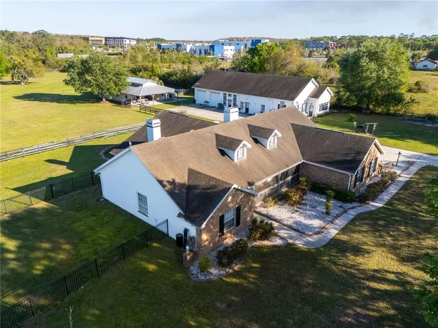 an aerial view of a house with swimming pool and lake view