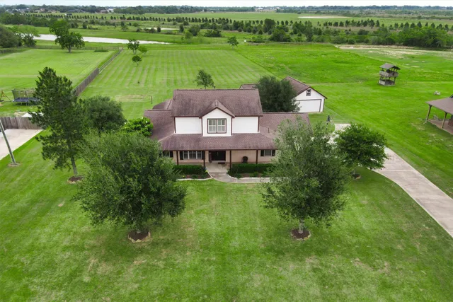 an aerial view of a house with a garden and lake view