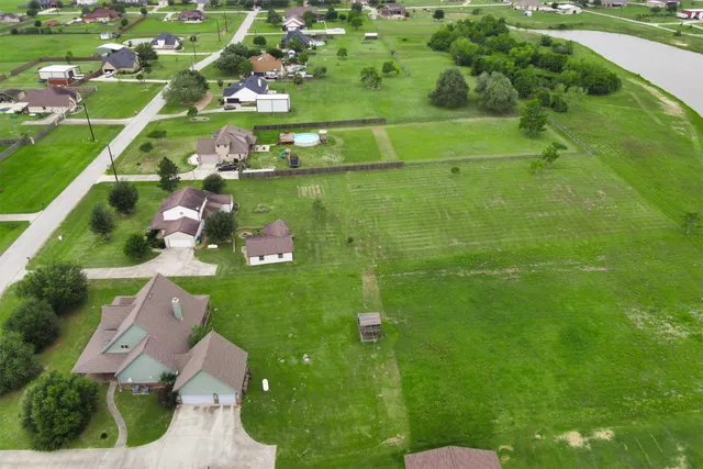 an aerial view of a house with pool a yard and lake view