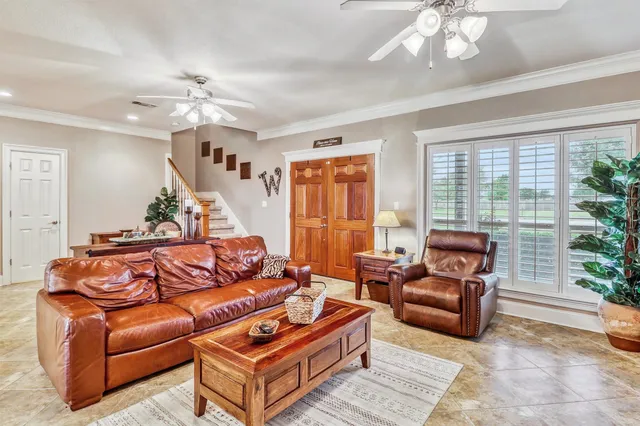 a living room with furniture ceiling fan and a window