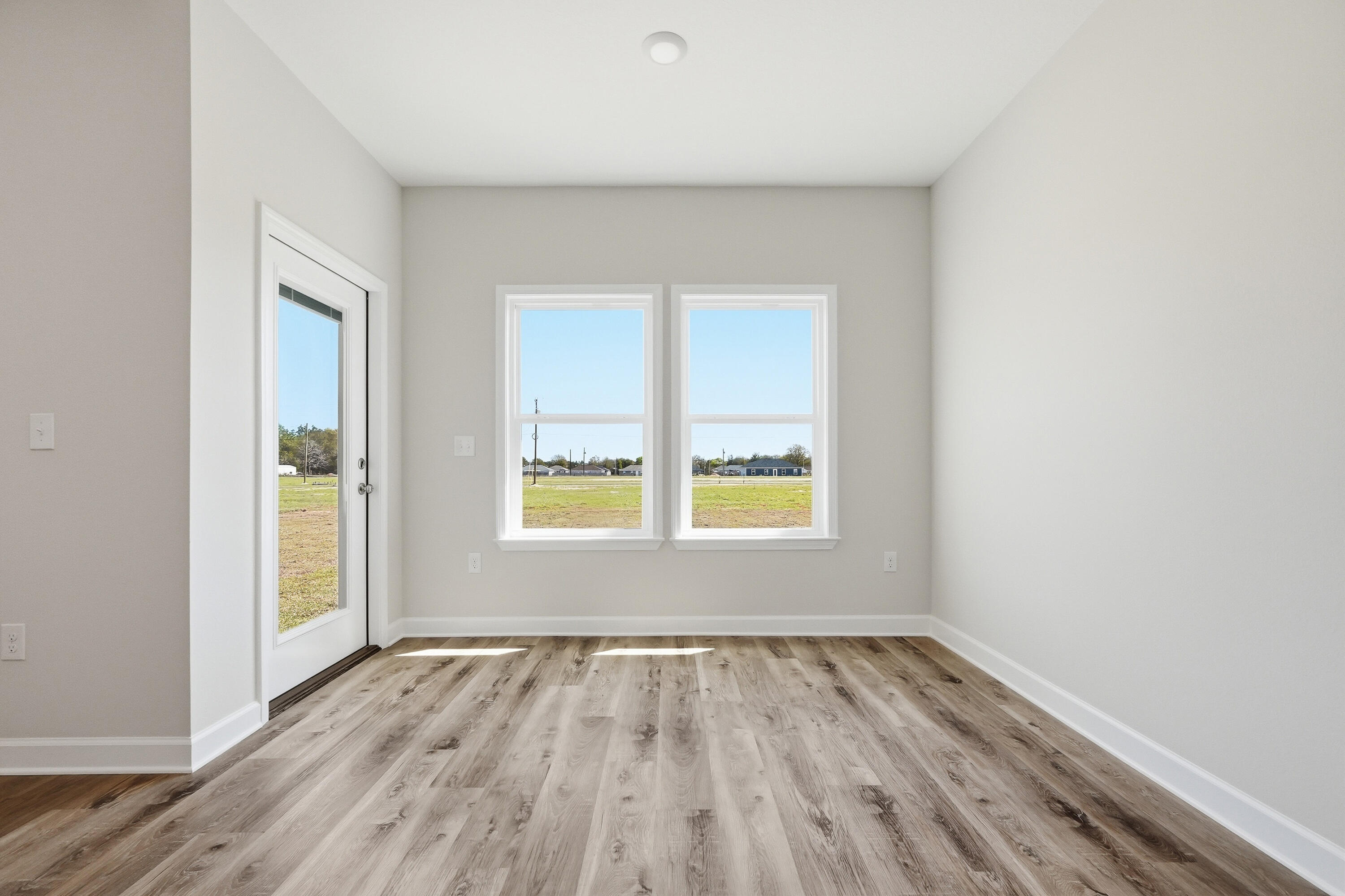 6114 Mildreds Way Crestview, FL 32539 - Photo 13 of 24 an empty room with a window and wooden floor