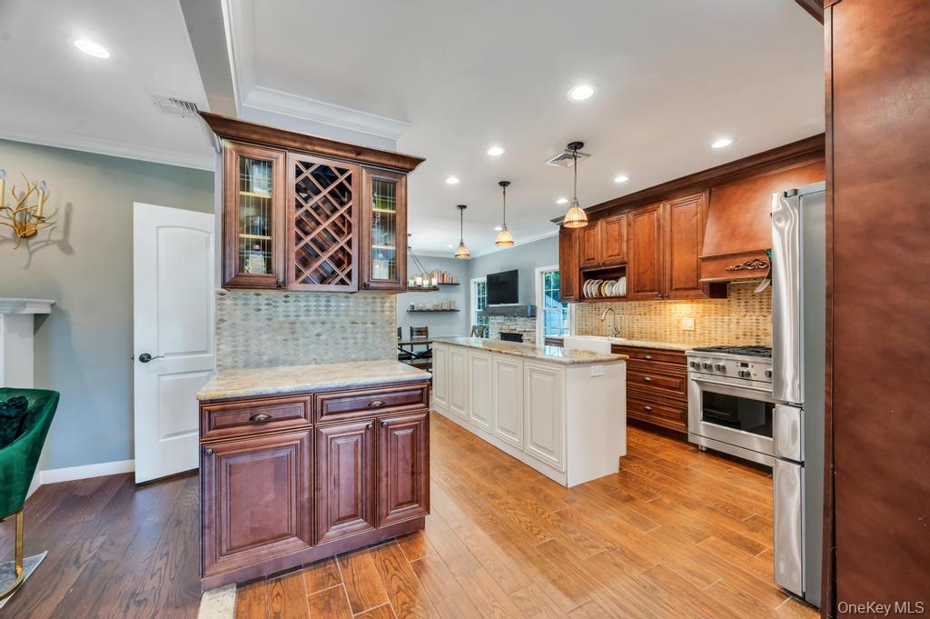 357 Wynsum Avenue Merrick, NY 11566 - Photo 14 of 40 a kitchen with stainless steel appliances granite countertop wooden cabinets and a stove top oven