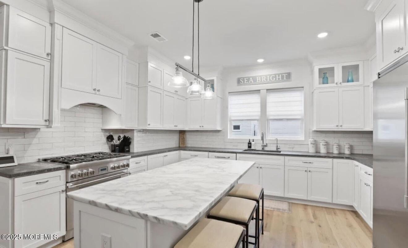 7 Center Street, Unit JUNE Sea Bright, NJ 07760 - Photo 5 of 19 a kitchen with granite countertop a sink a counter top space appliances and cabinets