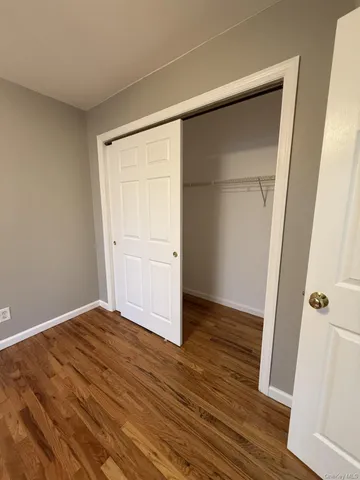 an empty room with wooden floor and closet