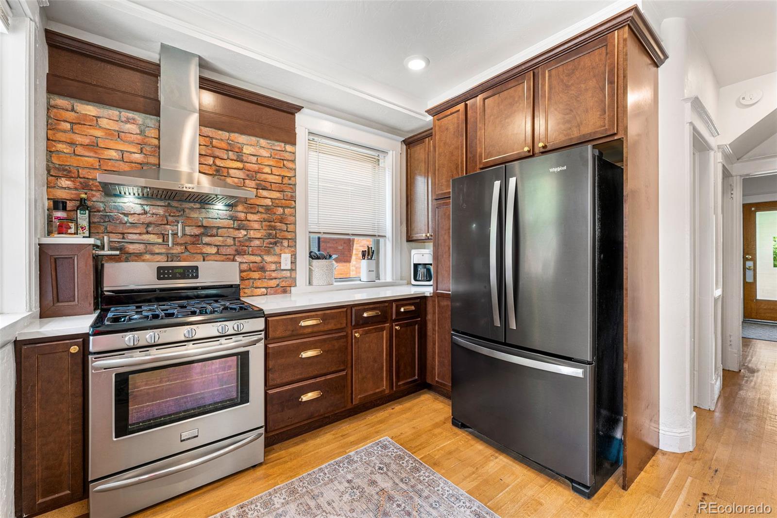 4425 Alcott Street Denver, CO 80211 - Photo 17 of 40 a kitchen with granite countertop a refrigerator stove and oven