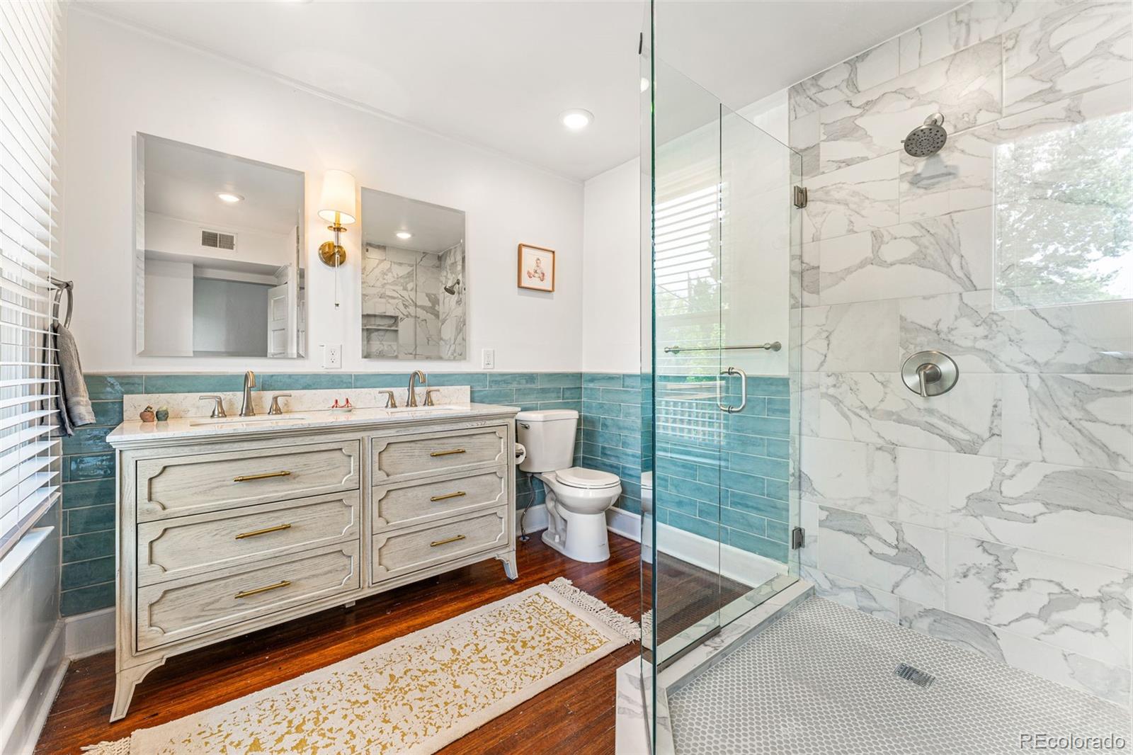 4425 Alcott Street Denver, CO 80211 - Photo 24 of 40 a bathroom with a granite countertop sink a toilet and shower