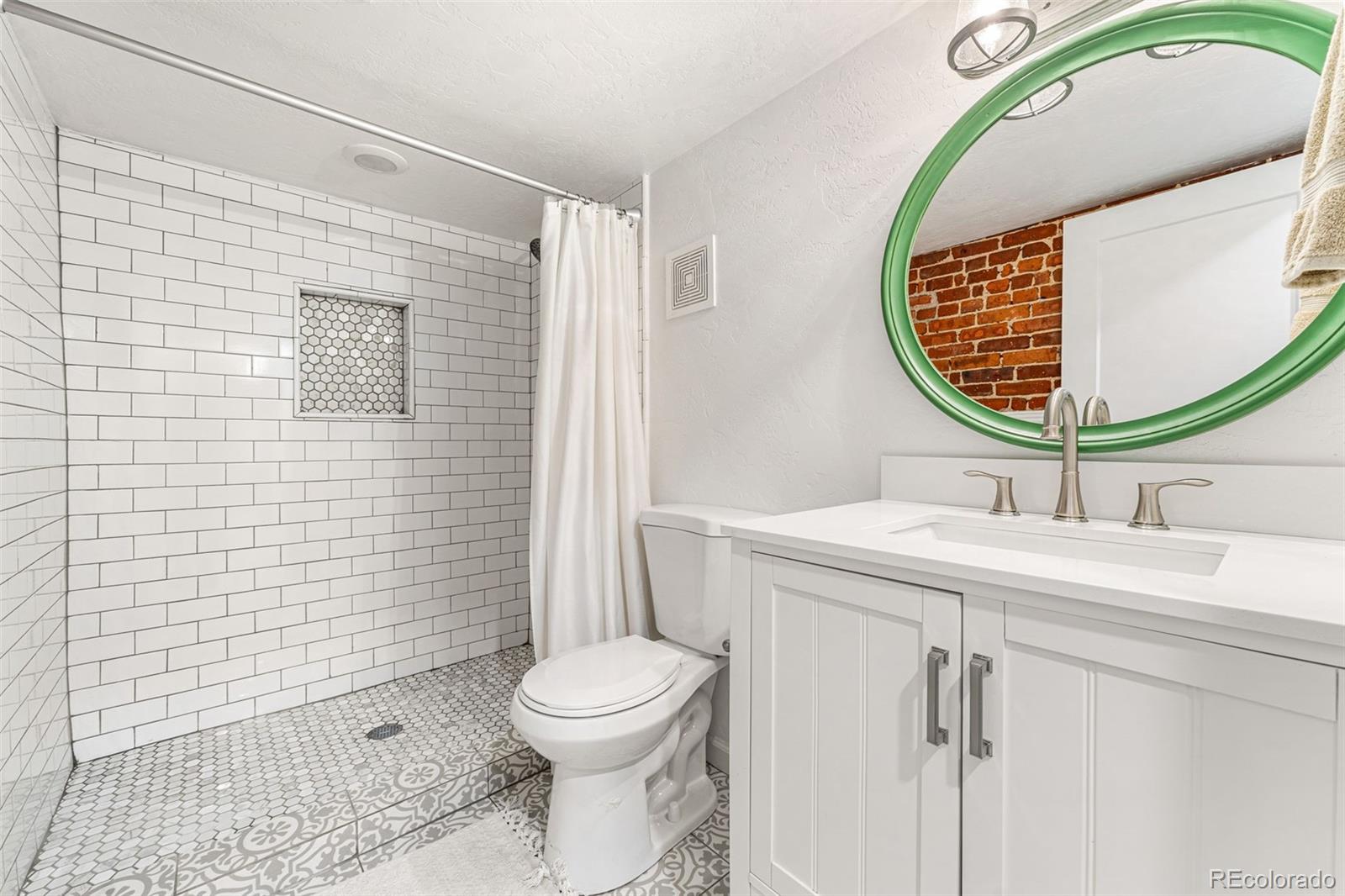 4425 Alcott Street Denver, CO 80211 - Photo 36 of 40 a bathroom with a sink mirror vanity and toilet