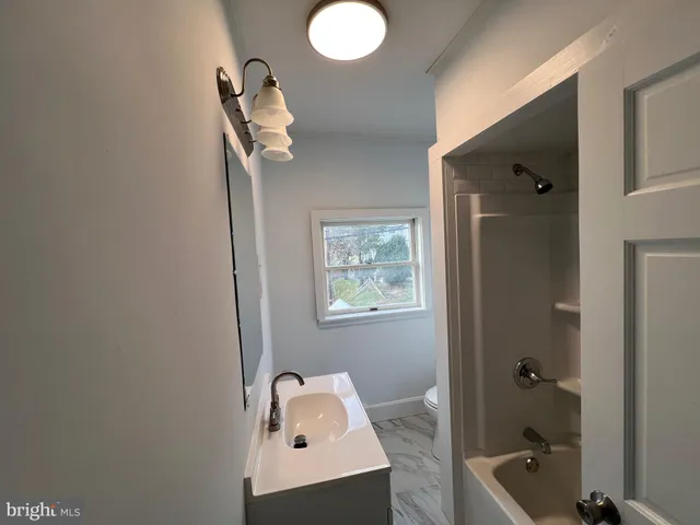 a view of a hallway with wooden floor and entryway