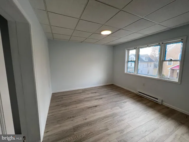 a view of empty room with wooden floor and fireplace