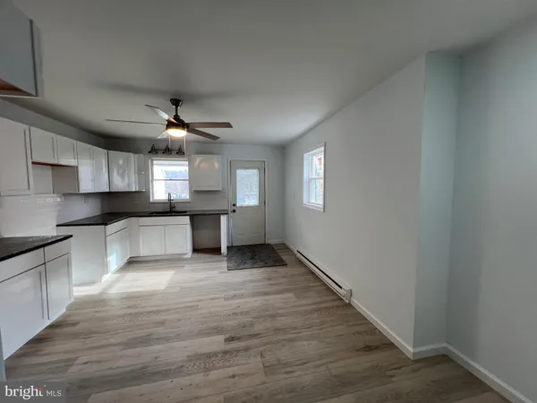 a large kitchen with cabinets wooden floor and stainless steel appliances