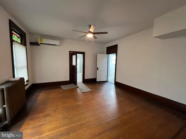 a view of a livingroom with wooden floor and a fireplace
