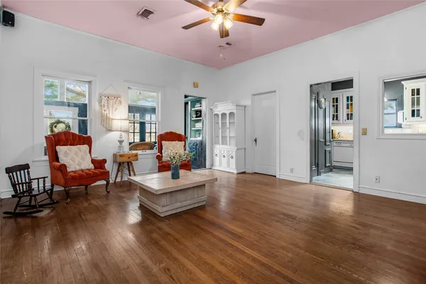 a living room with furniture and a wooden floor